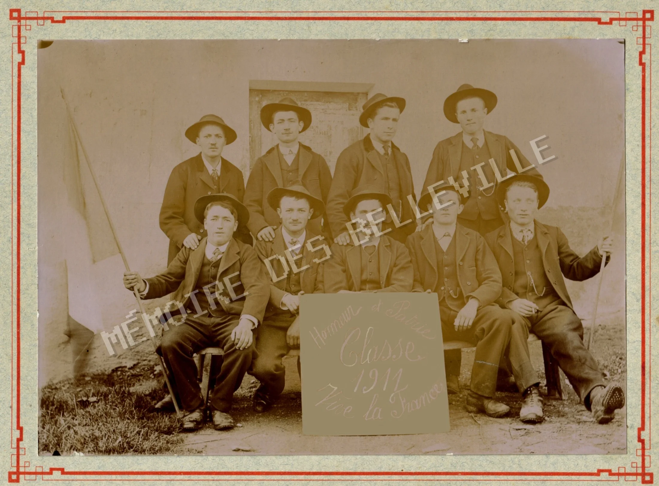 Les conscrits de Saint-Jean-de-Belleville de la classe 1911, réunis autour de la devise « Honneur et Patrie - Vive la France ». Neuf conscrits de Saint-Jean-de-Belleville de la classe 1911 posant avec leurs chapeaux et la pancarte Honneur et Patrie.