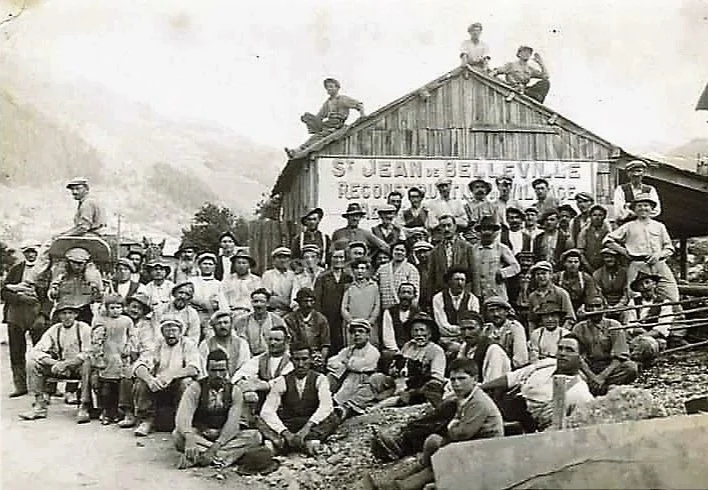 Ouvriers et habitants réunis lors de la reconstruction de Saint-Jean-de-Belleville après l’incendie du 27 août 1928, probablement vers 1929. Groupe d’ouvriers et d’habitants réunis sur le chantier de reconstruction de Saint-Jean-de-Belleville après l’incendie de 1928.