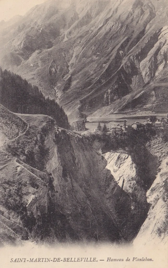 Carte postale ancienne du hameau de Planlebon à Saint-Martin-de-Belleville, en Savoie, montrant le village accroché à la montagne au bord d’un ravin.