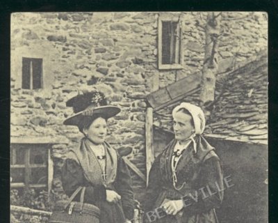 Deux femmes en costumes traditionnels de Savoie à Saint-Martin-de-Belleville vers 1900, photographiées devant une maison de pierre.