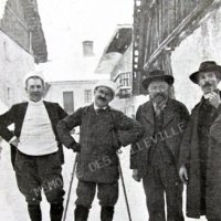 Antoine Borrel chaussé de skis, entouré de trois hommes en Savoie dans les années 1930.